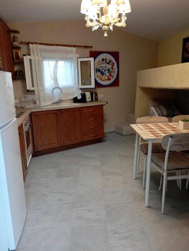 a kitchen with a table and a white refrigerator at Villa Art Natalie in Kithnos
