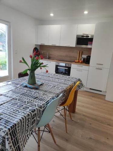 une cuisine avec une table avec un vase de fleurs dessus dans l'établissement La maison de la plage, à Plouézec