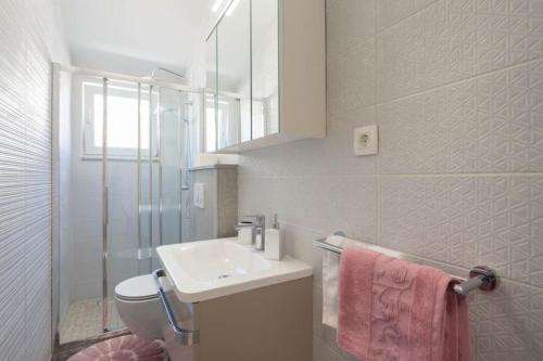a bathroom with a sink and a toilet and a mirror at DELUX 2 bedrooms Apartment near SPLIT - GOGA in Žrnovnica