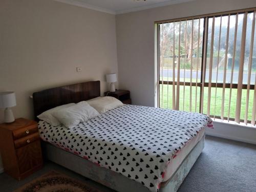 a bedroom with a bed and a large window at Pet Friendly in Port Elliot in Port Elliot