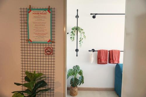 a room with a sign on the wall and a plant at The Kith Plus Sukhumvit 113 by BLK in Bangna