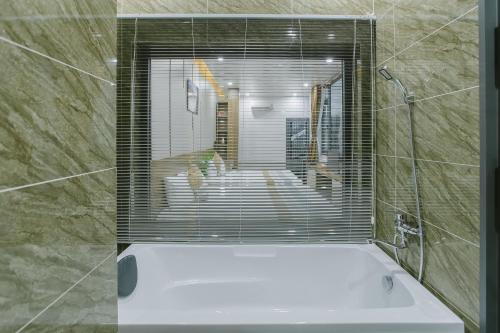 een badkamer met een bad en een raam bij Peony Hotel in Can Tho