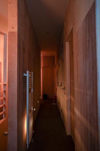 a hallway with wooden walls and a long hallway with doors at BEACH AND FIELD INN in Sapporo