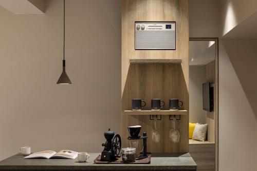 a kitchen with a counter with coffee cups and books at the b namba-kuromon in Osaka