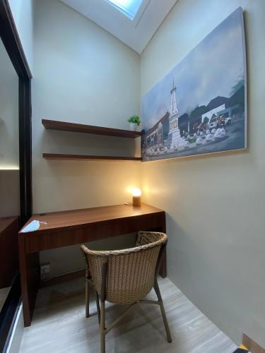a desk with a chair and a painting on the wall at Omah Soemantri 