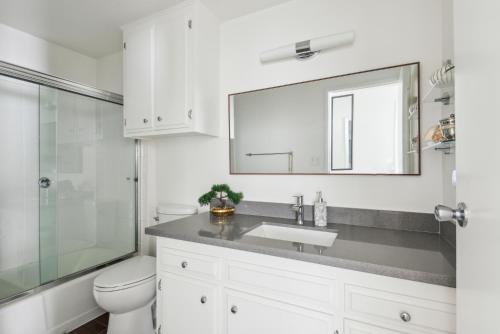 a bathroom with a sink and a toilet and a mirror at 2 Day Minimum - Spacious 1 Bedroom close to Beach in Long Beach
