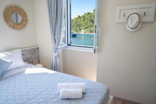 um quarto com uma cama branca e uma janela em The captain's bridge em Gaios