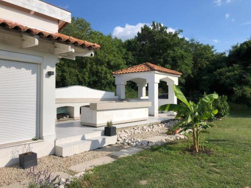 a white house with a gazebo at Borbara Apartman in Pázmándfalu