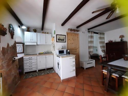 eine Küche mit weißen Schränken und einem Tisch mit einer Mikrowelle in der Unterkunft Nonna Elena in Rodi Garganico