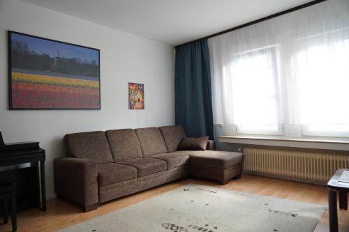 a living room with a couch and a window at Bright, spacious apartment with a lovely terrace in the heart of Aachen in Aachen