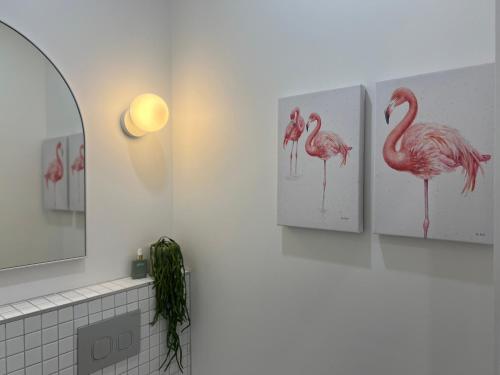 a bathroom with three pink flamingos on the wall at Modern Pool Oasis & Seaside Abode in Brighton