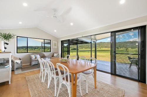 a dining room with a table and chairs at The House - The Charles at Broke Hunter Valley Luxury in Broke