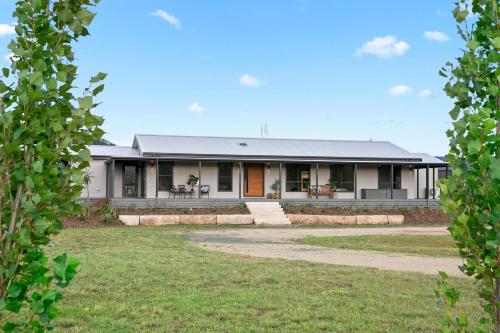 a house with a grass yard in front of it at The House - The Charles at Broke Hunter Valley Luxury in Broke