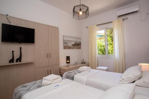 sypialnia z dwoma łóżkami i telewizorem na ścianie w obiekcie Hadrian by Heloni Apartments w Atenach
