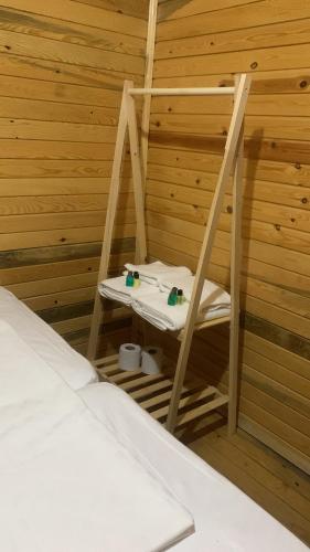 una silla de madera en una habitación con cama en Pina bungalov restaurant, en Ayvacık