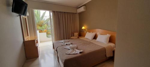 een hotelkamer met een bed met handdoeken erop bij Hotel Serenity Tolo in Tolo