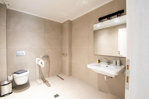 a bathroom with a toilet and a sink at Ennea suites-Earth suite in Flámbouras