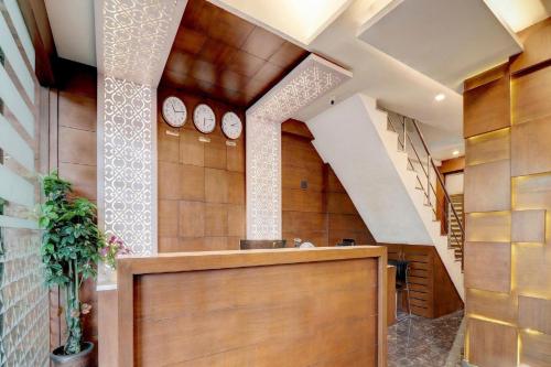 a hallway with clocks on the wall in a building at Pine Tree Signature in Chennai