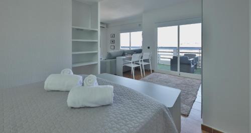 biała sypialnia z dużym łóżkiem i białymi poduszkami w obiekcie La Mar de Venus - Luxury Views in Puerto Deportivo w Marbelli
