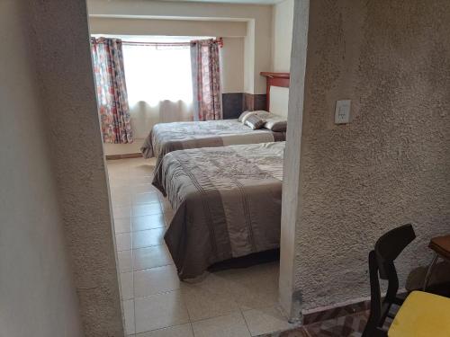 墨西哥城的住宿－Departamento Aeropuerto CDMX，一间卧室设有两张床和窗户。