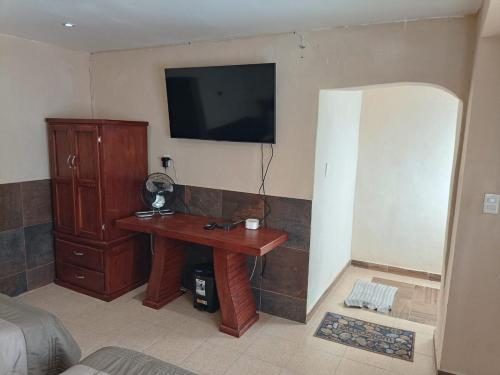 a bedroom with a desk and a television on the wall at Departamento Aeropuerto CDMX in Mexico City