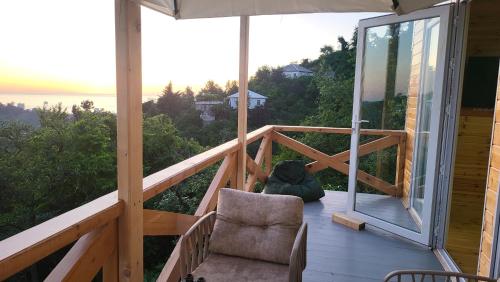 a porch with a chair and an umbrella at VILLA GANTIADI in Batumi
