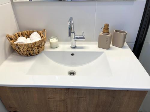 a bathroom counter with a sink and a basket of towels at ארץ מדבר - יחידת אירוח בבאר אורה in Beʼer Ora