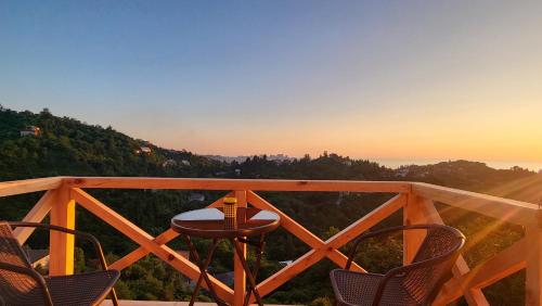 a table and chairs on a balcony with the sunset at VILLA GANTIADI in Batumi
