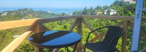 a table and chairs on a balcony with a view of the ocean at VILLA GANTIADI in Batumi