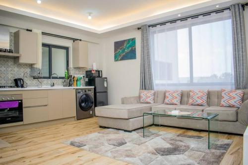 ein Wohnzimmer mit Couch und Tisch in der Unterkunft Urban Lifestyle 1BR in Westlands, Heated Pool, Gym, Workspace & Parking in Nairobi