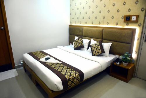 a bedroom with a bed with white sheets and pillows at Pine Tree Signature in Chennai