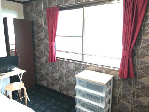 a room with a desk and a window with red curtains at COTE sakuragawa "Room 201,301,401" - Vacation STAY 03134v in Osaka