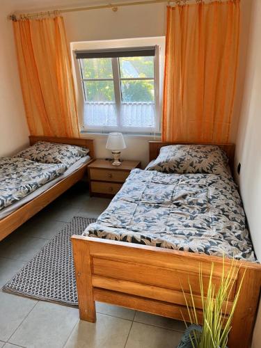2 camas en una habitación con ventana en Agroturystyka „U Rzeźbiarza”, en Sławno