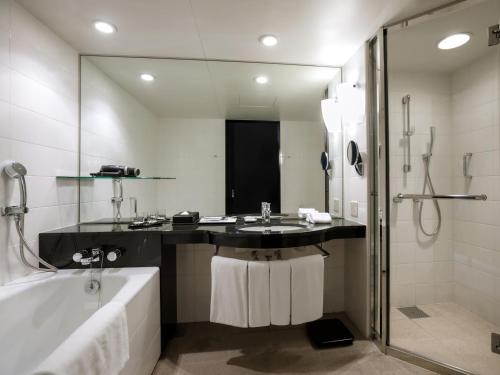 a bathroom with a sink and a tub and a shower at Grand Prince Hotel Osaka Bay in Osaka