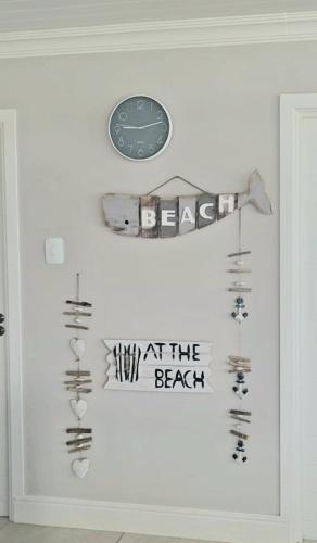 a wall with a clock and various items on it at Bella Vista Yzerfontein - No loadshedding - Home away from home in Yzerfontein
