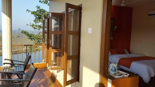 a bedroom with a bed and a balcony with a view at Jungle Wildlife Camp in Sauraha