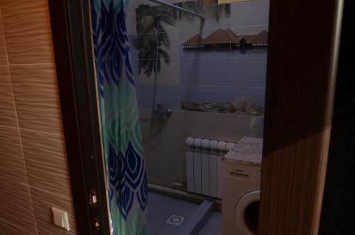 een badkamer met een bad en een wasmachine bij Woody Guest House Nursultan in Kaindy