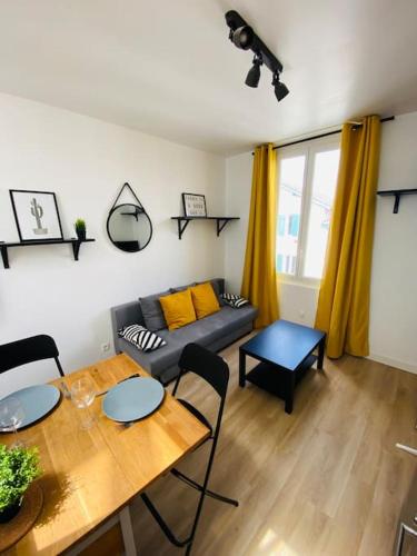 un salon avec une table et un canapé dans l'établissement Joli Duplex à quelques pas du centre de Bayonne, à Bayonne