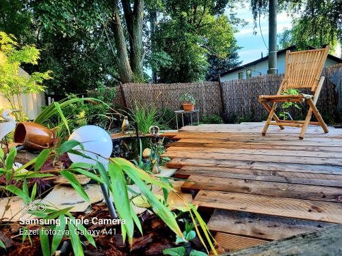 a wooden deck with a chair and a plant at Lazy Bee in Keszthely