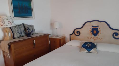 a bedroom with two beds and a wooden headboard at Casa Logos Stintino - Private pool in Stintino