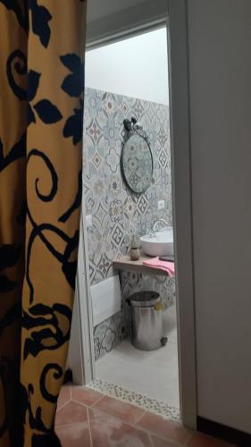 a bathroom with a sink and a clock on the wall at Casa Logos Stintino - Private pool in Stintino