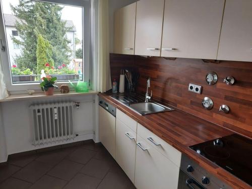 a kitchen with white cabinets and a sink and a window at Ferienwohnung Schallinger in Teisendorf