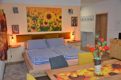 1 dormitorio con 1 cama, 1 mesa y 1 pintura en Apartmán Nad potokem, en Český Rudolec
