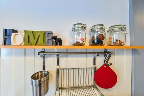 a shelf with three glass jars and a red spatula at My Place Ferdinand in Cluj-Napoca