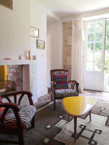 - un salon avec une cheminée, des chaises et une table dans l'établissement Gite La Tourelle Château de Montchevreau, à Cosne Cours sur Loire