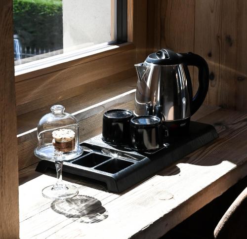 a tea kettle and cups on a tray on a stove at Grey Castle garnì&suite in Ponte di Legno