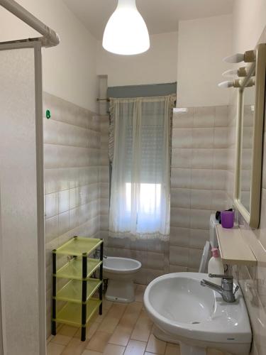 bagno bianco con lavandino e servizi igienici di Le Zagare apartments a SantʼAlessio Siculo