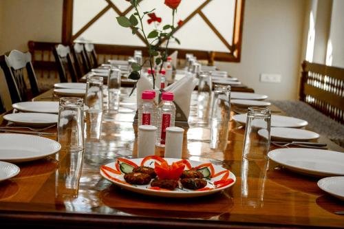 a long wooden table with a plate of food on it at Hotel Rime Vista in Jaipur