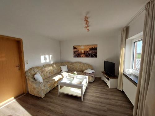 a living room with a couch and a table at Ferienwohnung Asmuss in Rabenholz in Rabenholz