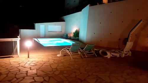 バスティアにあるAppartement de 2 chambres avec vue sur la mer piscine privee et terrasse amenagee a Bastia a 2 km de la plageのスイミングプール(椅子2脚、照明付)